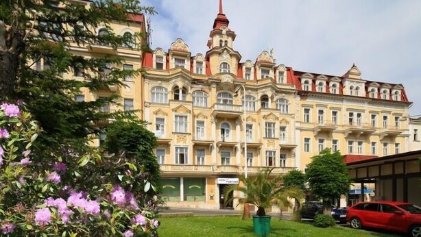 Un hotel grande y ornamentado con múltiples balcones y una torre destacada.
