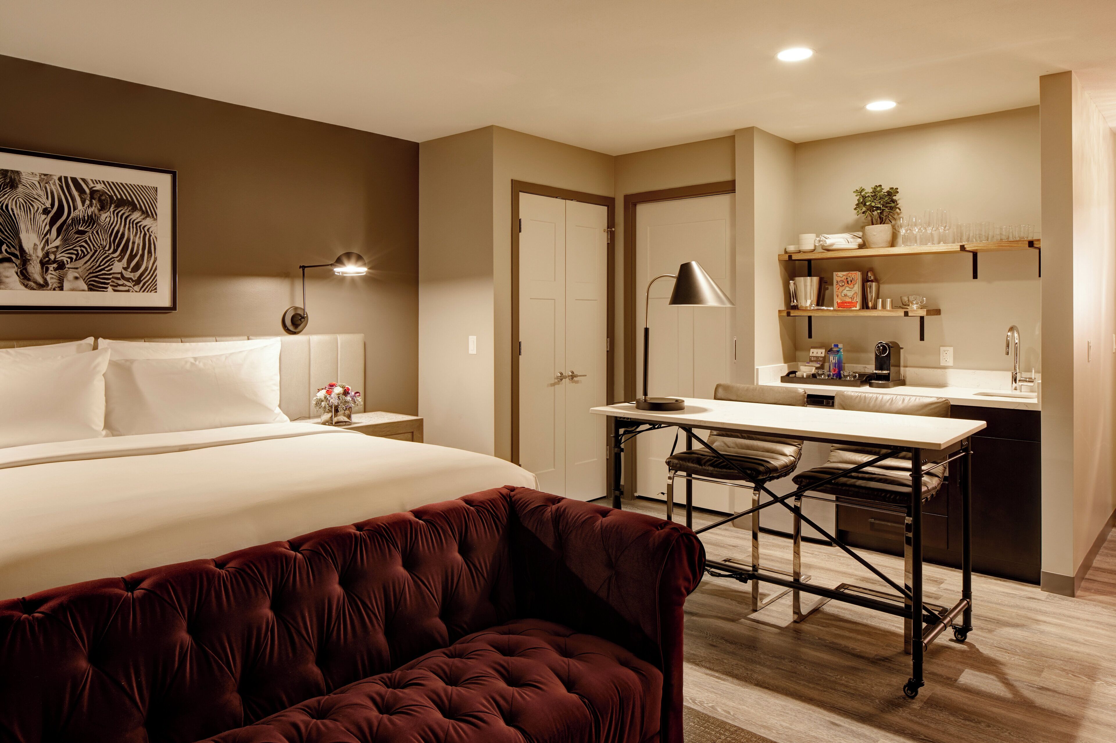 Una habitación de hotel con una cama, un escritorio, una silla y un sofá.