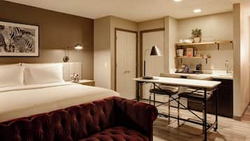 Una habitación de hotel con una cama, un escritorio, una silla y un sofá.