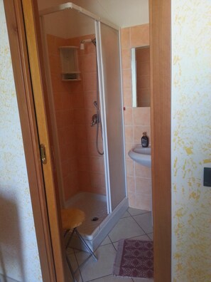 A bathroom with a shower, a sink, and a mirror. - Hotel Mistef (Falerna)