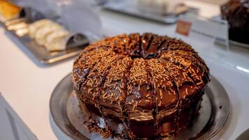 A chocolate cake with sprinkles on a metal plate.
