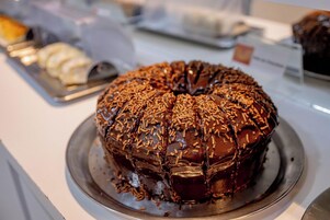 Un gâteau au chocolat décoré de vermicelles colorés, présenté sur une assiette en métal.