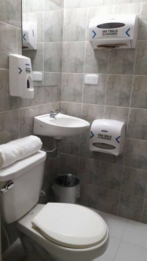 A bathroom with a toilet, sink, and two hand dryers. - La Perla Hostel (Santa Marta)