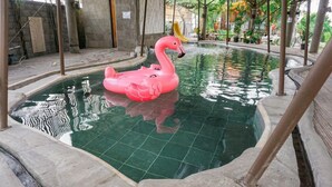 A swimming pool with a pink flamingo float. - Vila Air Natural Resort (Lembang)