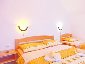A hotel room with two beds, each with a wooden headboard, a bedside table, and a wall-mounted light fixture. - House Zdravko (Plitvicka Jezera)
