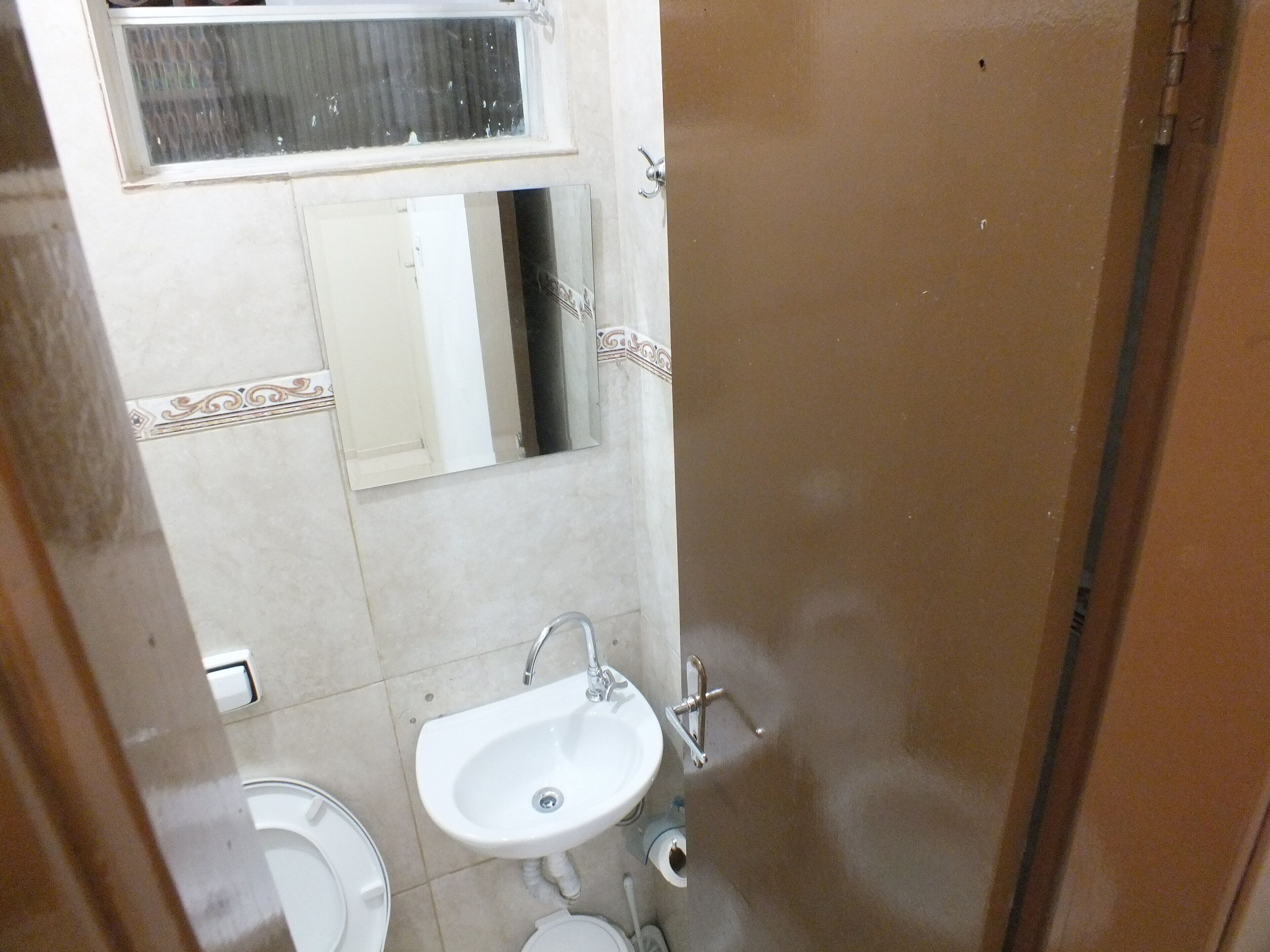 Un baño con inodoro, lavabo y espejo.