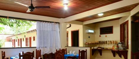 A dining area with wooden ceiling and tables set for a meal.