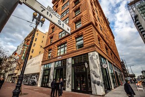A corner building with a large sign for 7th Street and a visible entrance to a building with a glass facade.