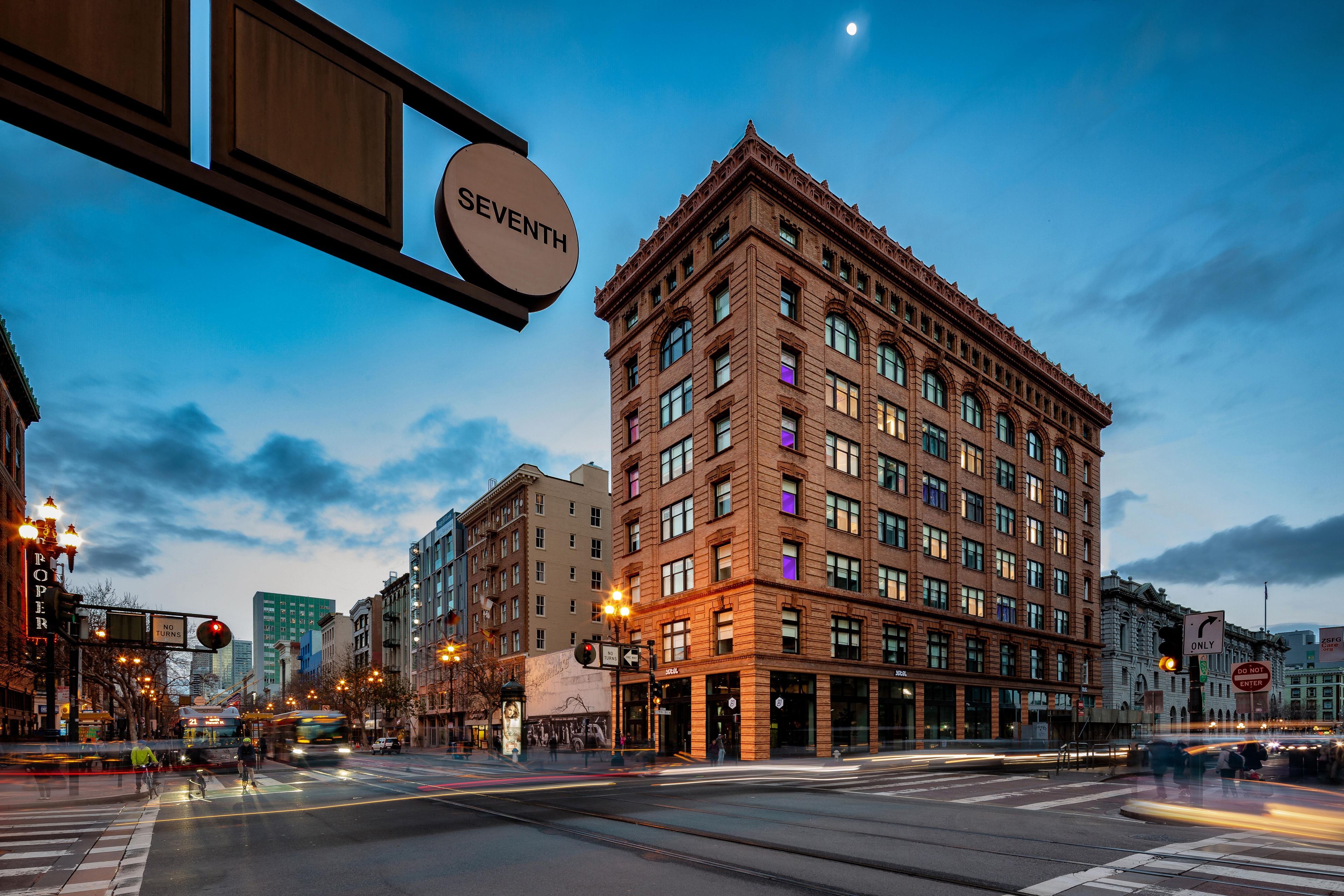 A multi-story building with a classic architectural style, featuring a prominent corner entrance and a large sign indicating the address.
