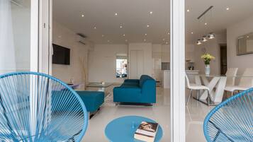A modern living room with a sofa, a coffee table, and blue chairs.