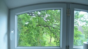 A room with a large window offering a view of a lush green landscape. - Pferdehof Muhlitz on Rügen, an idyll for individualists (Samtens)