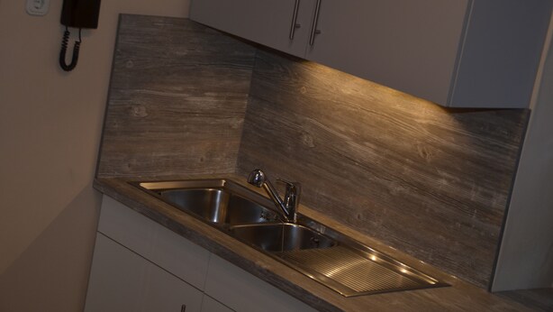 A modern kitchen with stainless steel sinks, wooden cabinetry, and a built-in telephone. - Wonderful view of the Nahe Valley and the Frombork (Sonnenberg-Winnenberg)