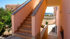 Eine Steintreppe führt zu einem Balkon mit freiem Blick auf die umliegende Landschaft.