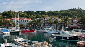 A marina with various boats docked, surrounded by residential buildings and palm trees. - Last minute for June - romantic villa with pool and BBQ, 6 min from the sea (Podgora)