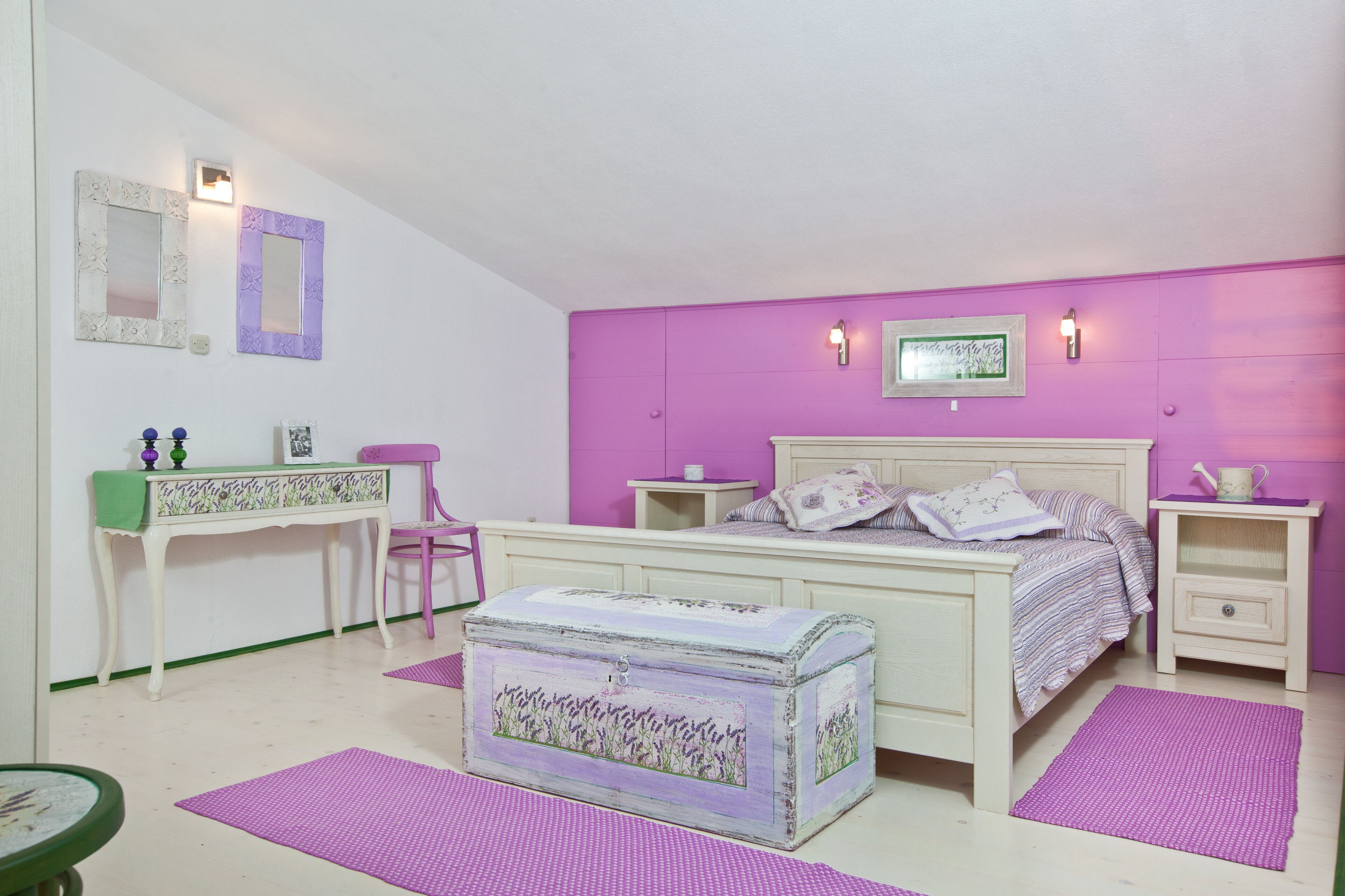 Ein Schlafzimmer mit einem Bett, einem Schreibtisch, einem Stuhl, einem Nachttisch, einer Kommode und einer Anrichte.