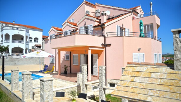 A two-story building with a swimming pool, outdoor seating, and a statue. - Villa Flipa with pool Ap. Ema (Vodice)