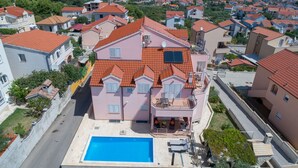 A multi-story building with a swimming pool, balconies, and a red-tiled roof. - Villa Flipa with pool Ap. Ema (Vodice)