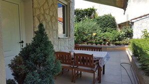 A patio with a table and chairs, a stone wall, and a small tree. - Ginkgo 3 - Holiday apartment for 3 people, close to the sea (Banjole)