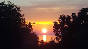 A sunset with the sun partially obscured by trees. - Ginkgo 4 - Holiday apartment for 4 people, close to the sea (Banjole)
