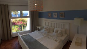 A bedroom with a bed, a nightstand, a lamp, and a view of the outdoors. - Sea view with a view  (Canico)