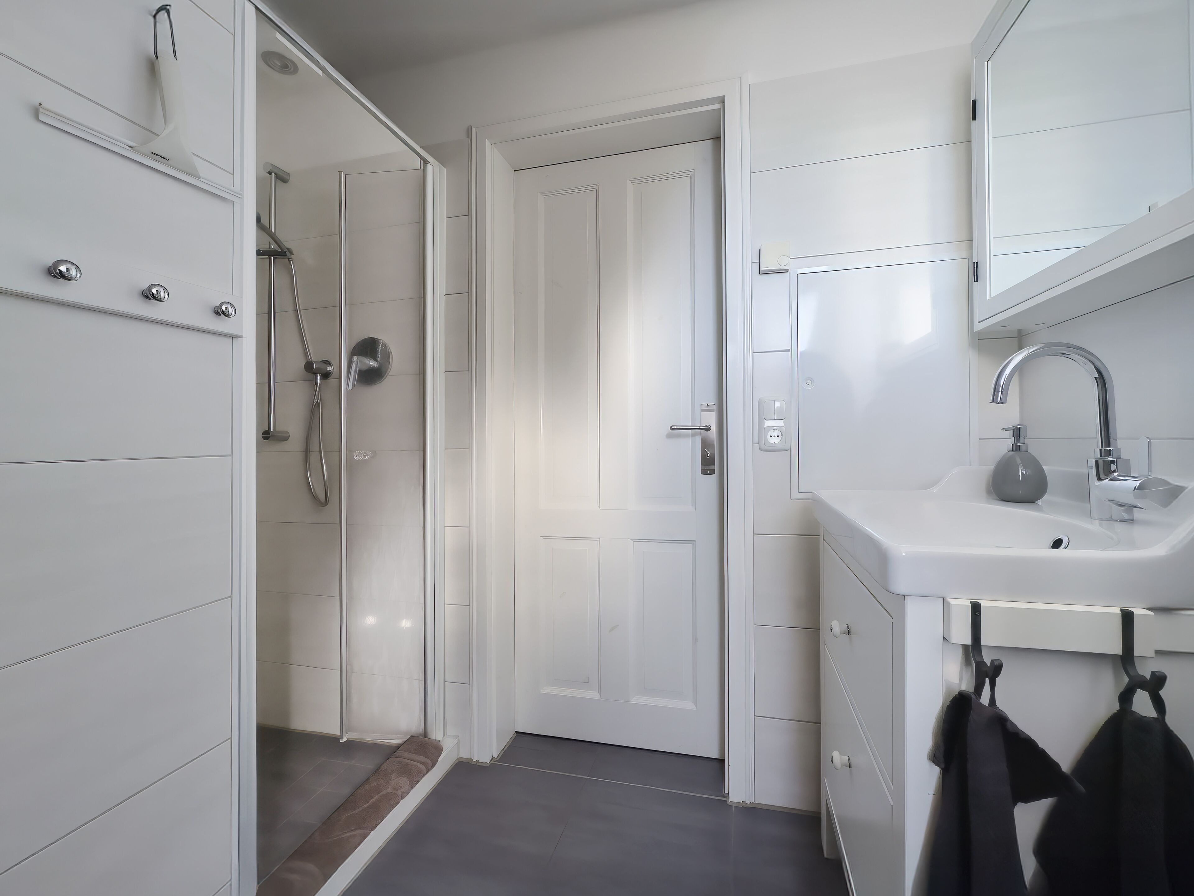 A modern bathroom with a shower, sink, and mirror.