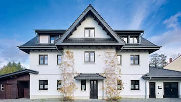 Ein zweistöckiges Gebäude mit einer symmetrischen Fassade, einem zentralen Eingang und einem Ziegeldach.