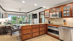 A spacious kitchen with wooden cabinets, a built-in microwave, oven, and dishwasher.