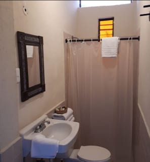Habitación cuádruple, 2 camas matrimoniales | Baño | Regadera, regadera tipo lluvia, amenidades de baño gratuitas, toallas 