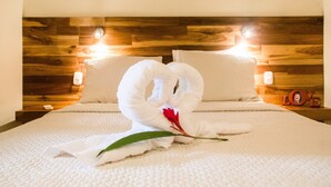 A hotel room with a wooden headboard, two pillows, and a bed with a white textured bedspread.