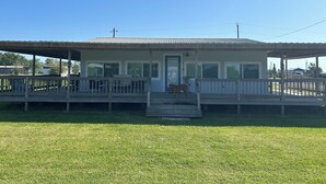 A small, single-story building with a porch and a covered area, likely a small business or service station. - Cozy beach cottage in Magnolia (Port Lavaca)