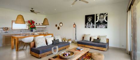 A spacious living area with a wooden coffee table, two sofas, and a dining table.