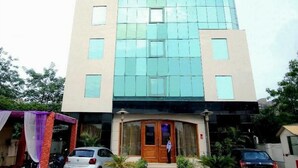 Un hôtel appelé Hotel Rousha Inn, doté d’une façade moderne, de grandes fenêtres et d’une entrée accueillante.