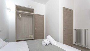 Una habitación de hotel con cama, armario y radiador.