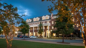 Un hôtel à la façade en briques, doté de nombreuses fenêtres et d’une enseigne indiquant : « The Inn at Patrick Square ».