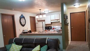 A living room with a sofa and a kitchen in the background. - Ski get away 10 minutes to Terry Peak★Deadwood★ Local Brewery across st (Lead)