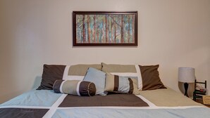 A neatly made bed with a patterned bedspread, a framed artwork above it, and a bedside table with a lamp and a small decorative item. - Ski get away 10 minutes to Terry Peak★Deadwood★ Local Brewery across st (Lead)