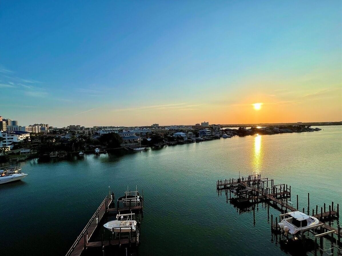 A marina with boats docked, a clear sky, and a sunset.