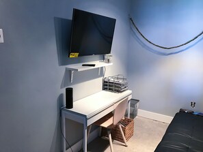 Cozy retreat with a flat-screen TV, desk, and comfortable couch.