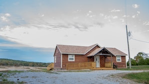 A wooden cabin with a porch, a small front window, and a door. - On the Wine Trail - Shawnee & Giant City Minutes Away- Jetted Tubs (Makanda)