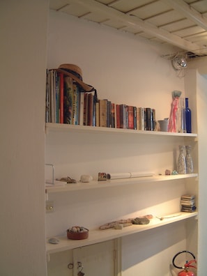 A bookshelf with books, a hat, and decorative items.