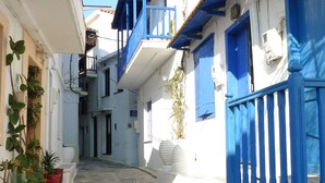 A narrow street with white buildings and blue doors and windows. - Agapi Nefeli, unique roofterrace view to sea port & town island MamaMia Skopelos (Skopelos)