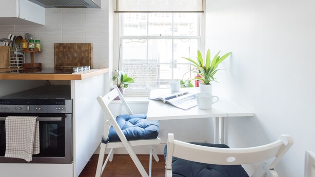 A kitchen with a window, a table with a magazine, and a chair. - Cozy Fitzrovia studio on a quiet cobbled street in the West End! (London)