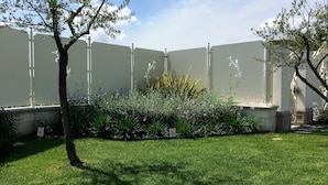 A fenced garden area with a variety of plants and a tree. - Exclusive Tuscan Villa with Black Pool & Jacuzzi (Altopascio)