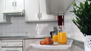A kitchen with white cabinets, a granite countertop, a stove, and a coffee maker. - Apartment/ flat - AyamonteResidential flat (Ayamonte)
