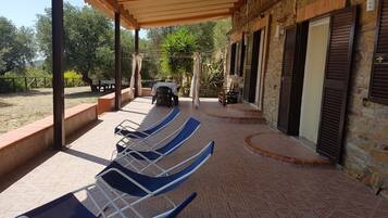 Relax in a tranquil outdoor space with lounge chairs and a shaded pergola.