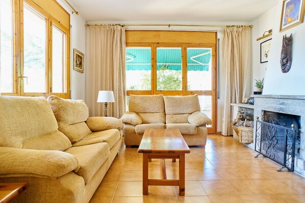 Una sala de estar acogedora con un conjunto de sofás, una mesa de centro de madera y una chimenea.