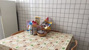 A kitchen table with a patterned tablecloth, a basket of snacks, and various food items. - Rome: Apartment/ flat - Roma (Roma)
