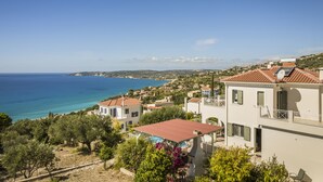 Una zona residencial costera con casas, cielo azul despejado y vista al mar.