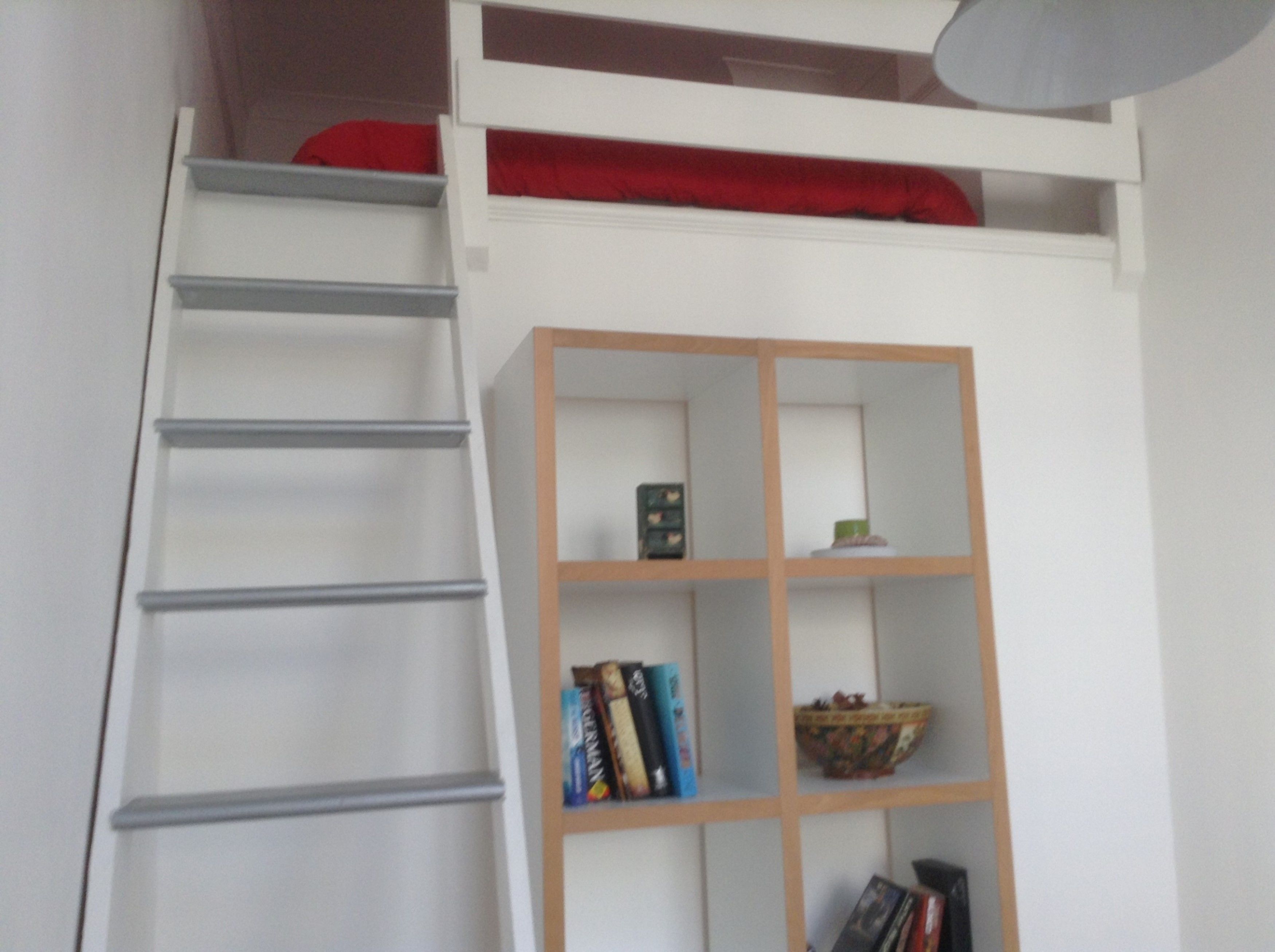 A staircase with a wooden bookshelf containing books and decorative items.