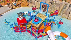 Um parque aquático com uma estrutura de recreação com tema de pirata, incluindo escorregadores e um navio naufragado.